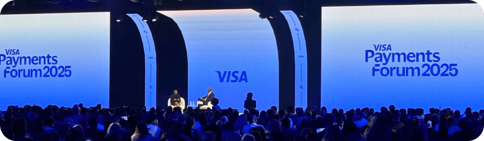 Visa Payments Forum 2025 conference stage with two speakers seated before a large audience